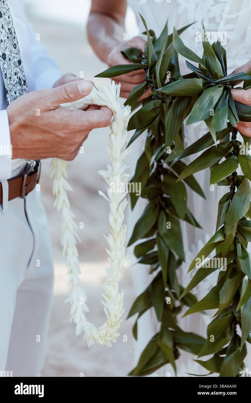 Ein Paar hält hawaiianische Lei im Beach Elopement Stockfoto