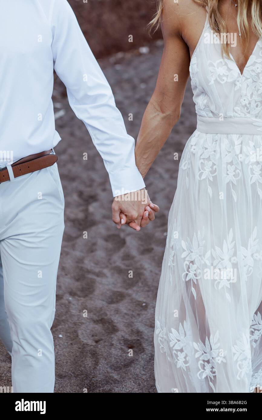 Frisch vermählte Hände am Black Sand Beach Stockfoto