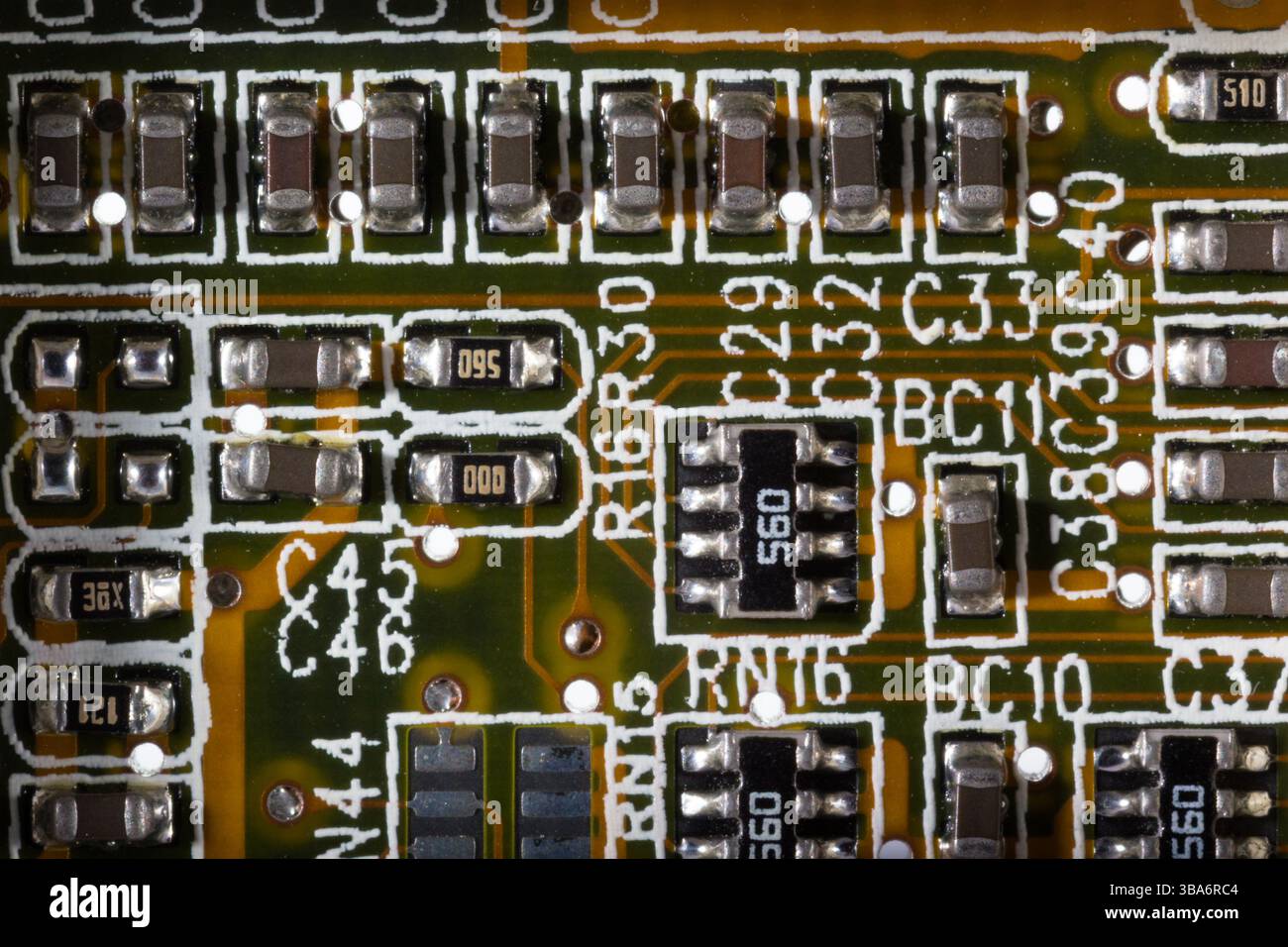 Ein Makrofoto, das elektronische Komponenten sorgfältig auf einer Leiterplatte zeigt. Das Bild zeigt das komplizierte Design, einschließlich Widerständen Stockfoto