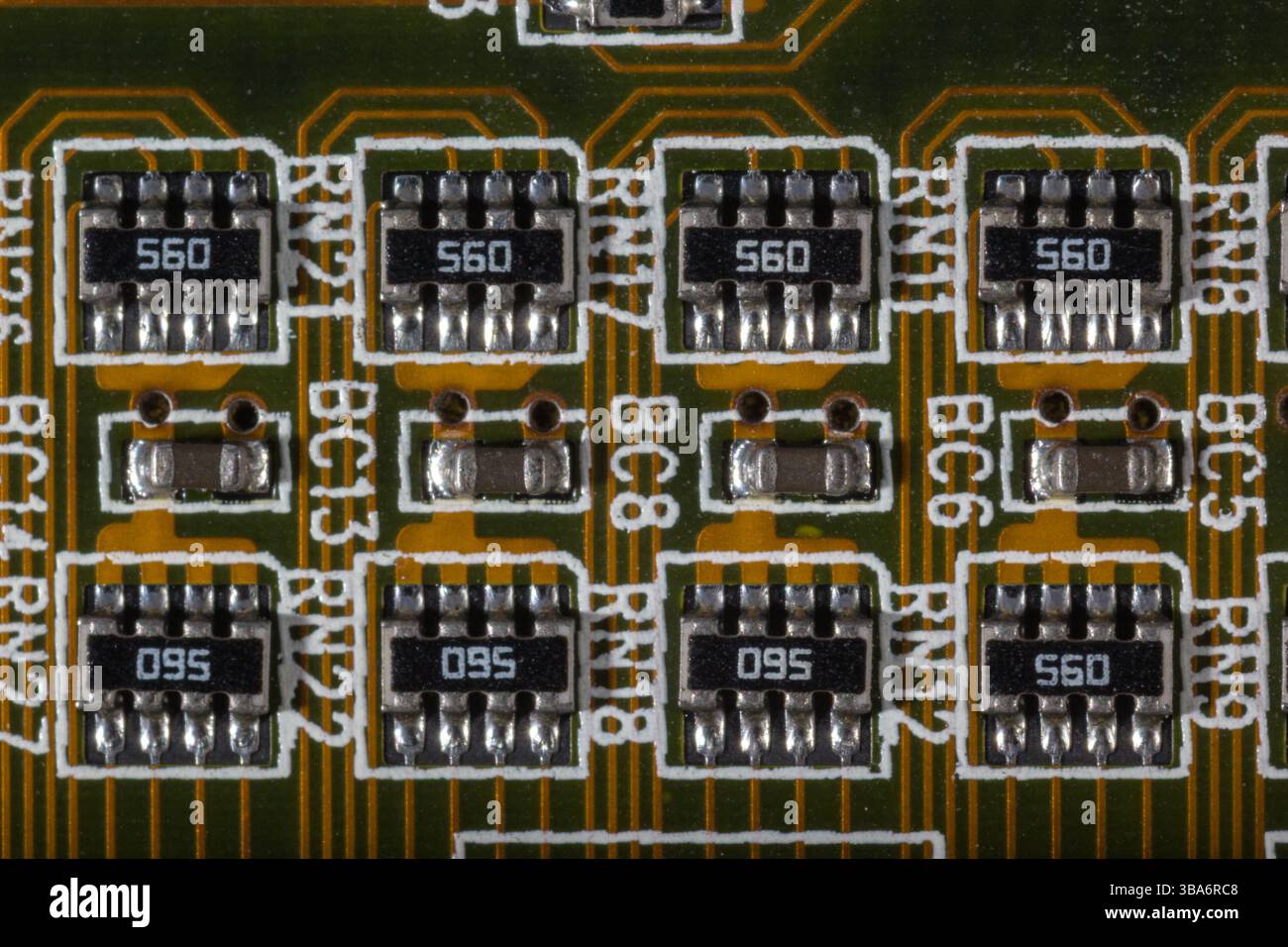 Ein Makrofoto, das elektronische Komponenten sorgfältig auf einer Leiterplatte zeigt. Das Bild zeigt das komplizierte Design, einschließlich Widerständen Stockfoto