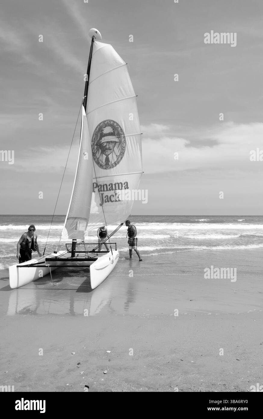 Kaukasische Männer bereiten sich darauf vor, ein Panama Jack-Segelboot vom Strand in Myrtle Beach, South Carolina, USA, zu starten. Stockfoto