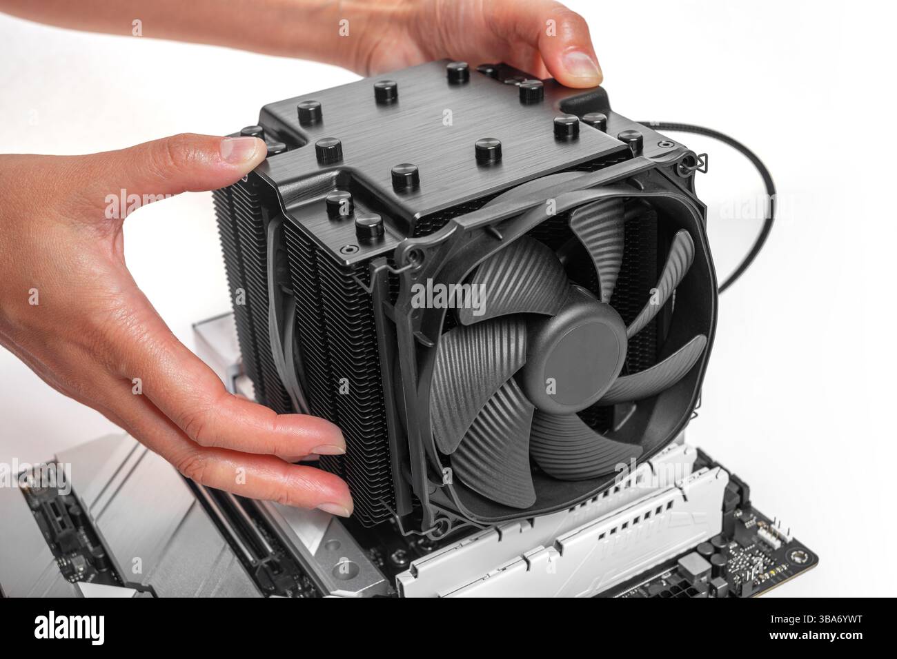 Eine Person installiert einen großen schwarzen CPU-Kühler im Tower-Stil Stockfoto