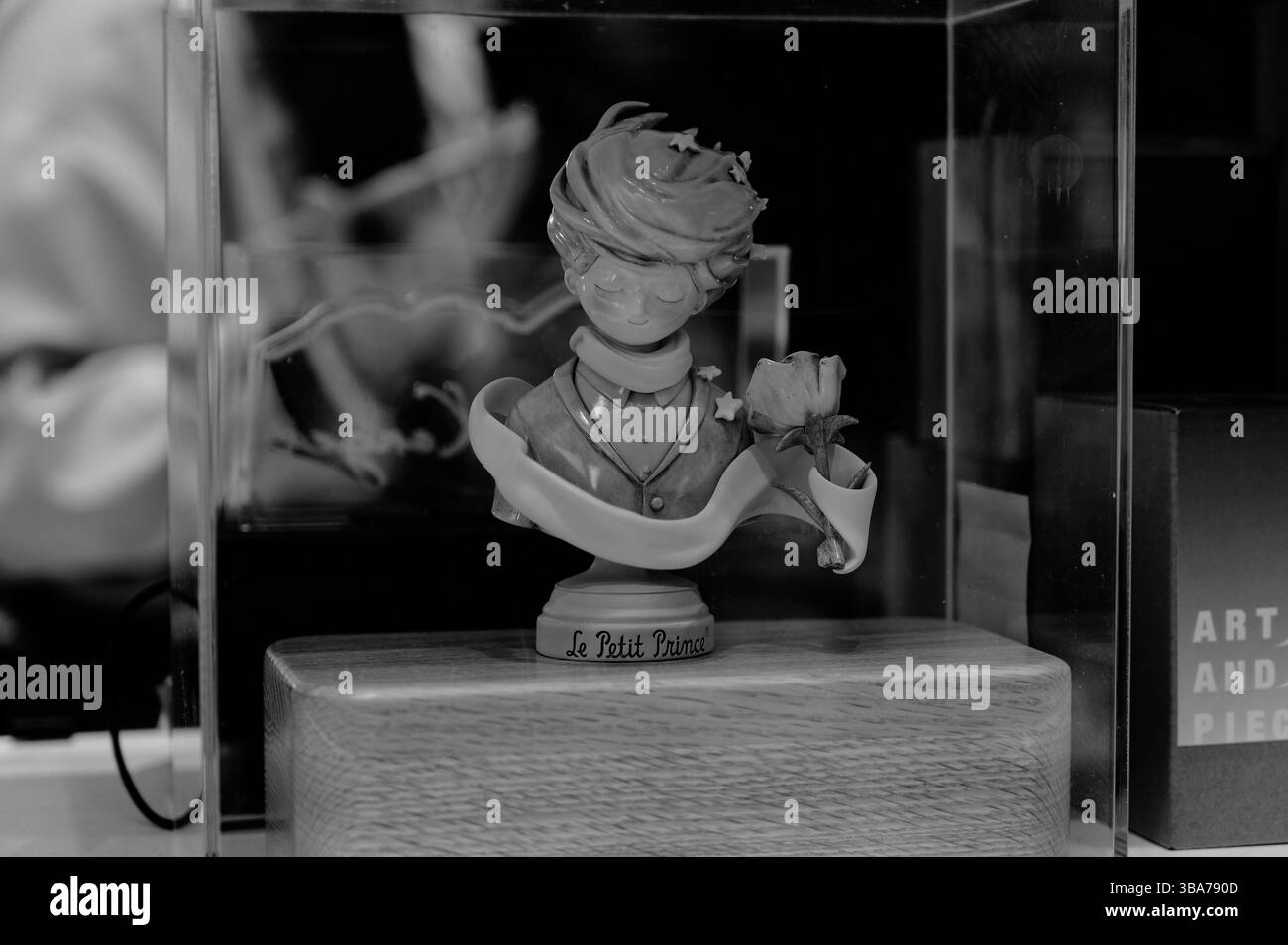 Schwarz-weiße Le Petit Prince Figur in einem Glasetui Stockfoto