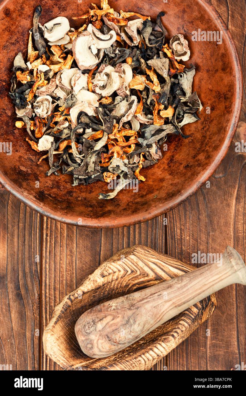 Eine lebhafte Auswahl an getrockneten Pilzen auf einem rustikalen Holztisch Stockfoto