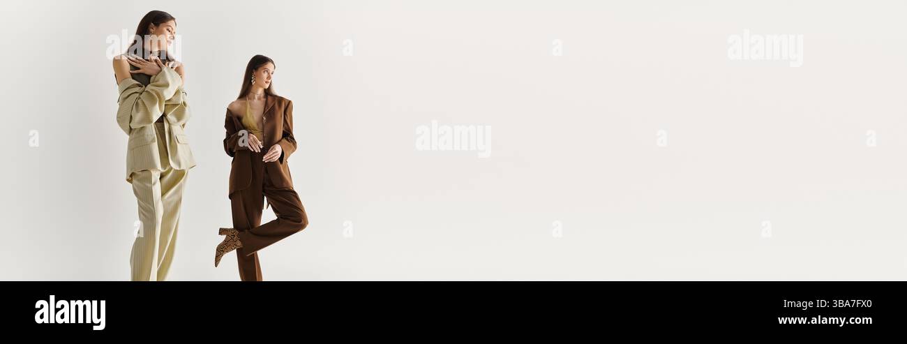 Elegante Zwillingsschwestern zeigen kontrastierende Stile und genießen die Gesellschaft und Verbundenheit miteinander. Stockfoto