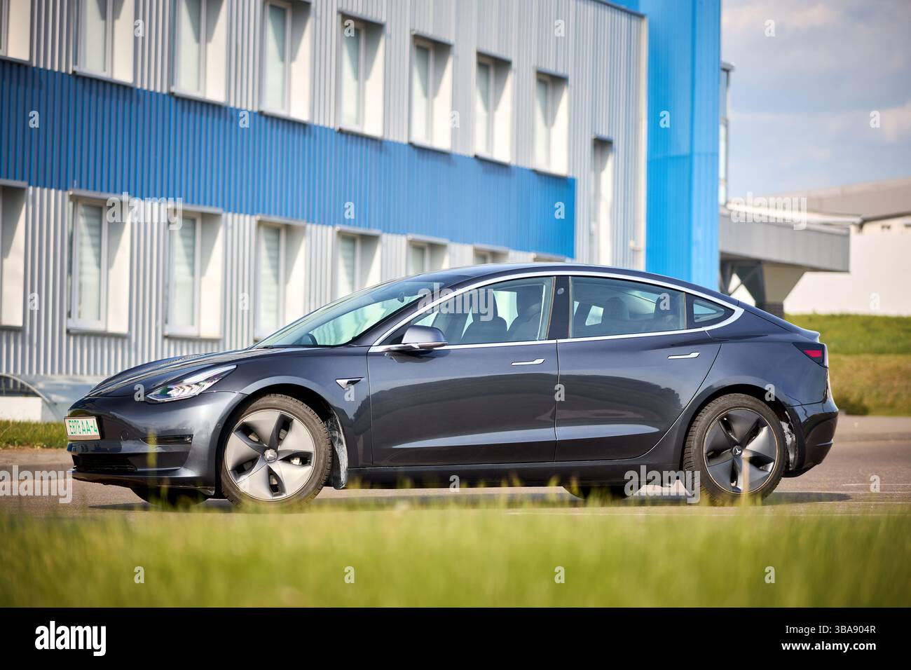 Berlin, 4. Mai 2024: Tesla Model 3 54 kWh Standard Range Plus 2019 selektiver Fokus über außerfokussiertem urbanem Hintergrund. Tesla Model 3 Batterie Stockfoto