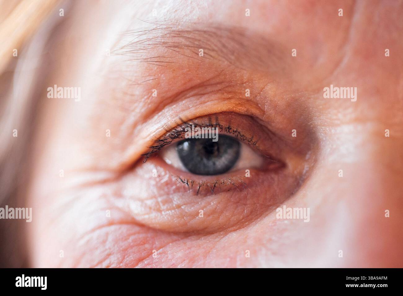 Nahaufnahme einer älteren Frau mit blauem Auge. Das Gesicht einer Reifen Dame mit Gesichtsfalten und ohne Make-up. Kopierbereich Stockfoto