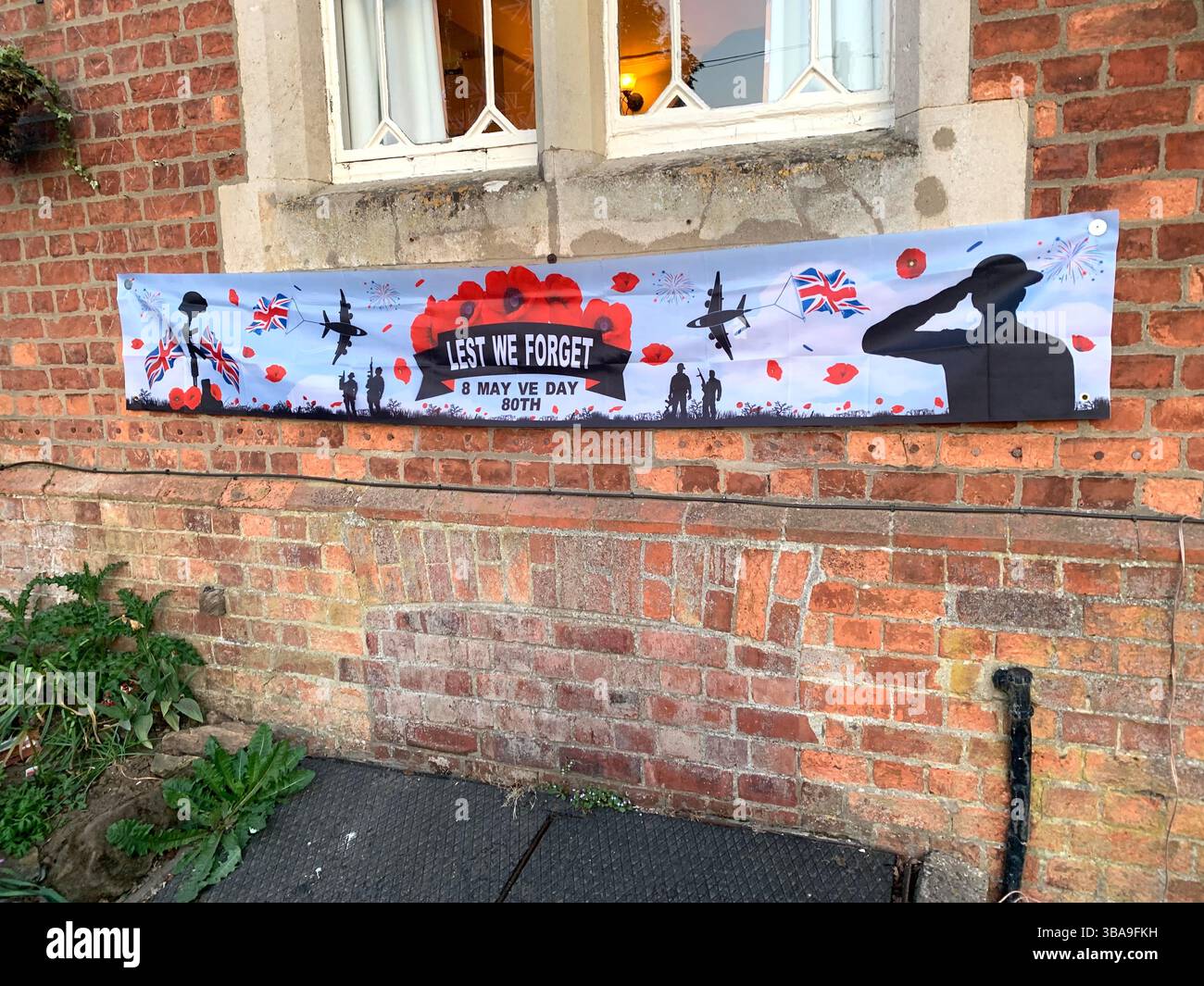 Menschen essen in einer Kneipe essen Essen Soldaten Militärplakat Kriegsflagge 80 Jahre Tag Veranstaltung Flaggen feiern das Ende des Krieges - Smartphone-aufgenommenes Stockfoto