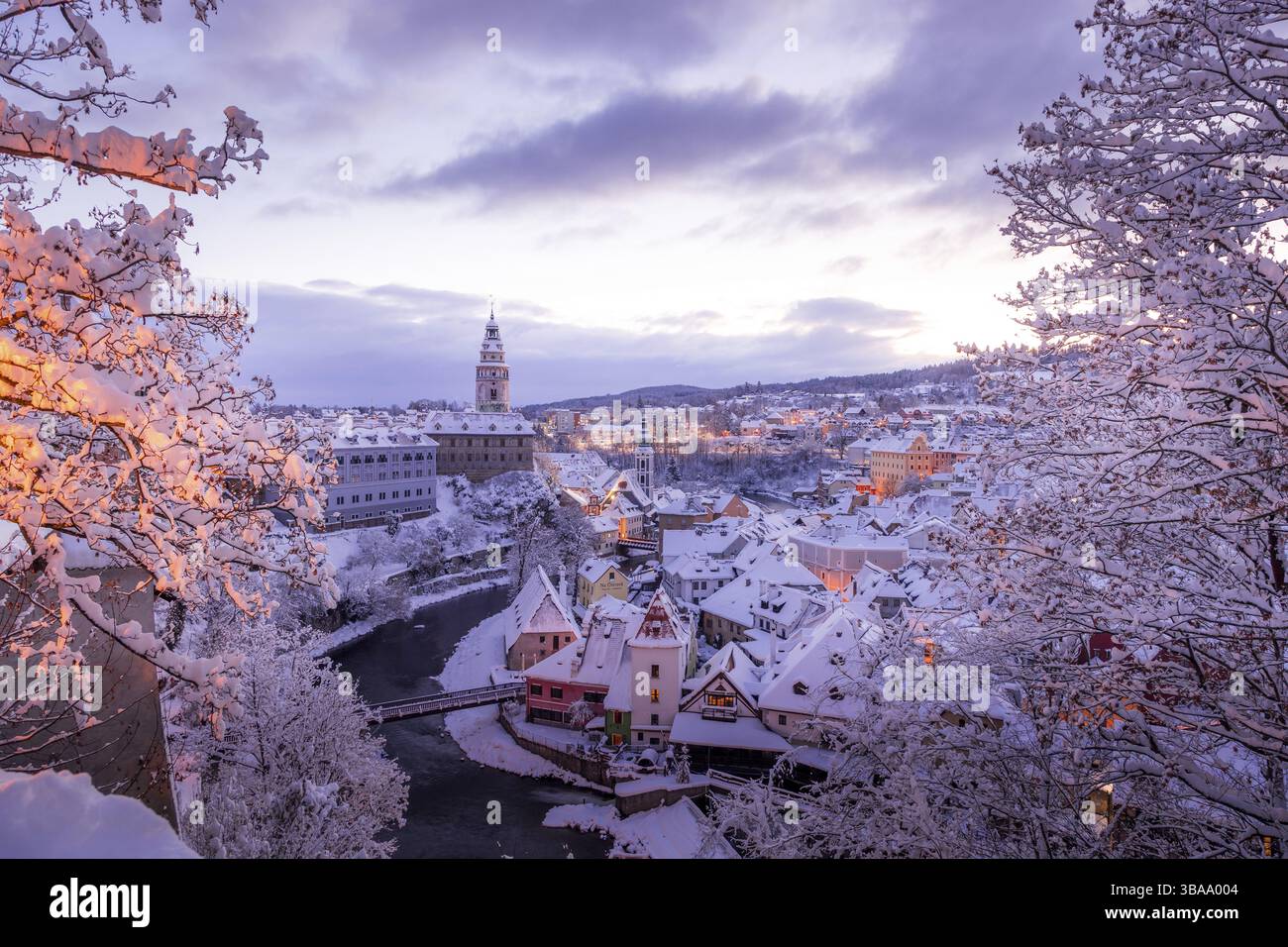 Winterblick auf Cesky Krumlov, malerische Häuser unter dem Schloss mit schneebedeckten Dächern. Enge Gassen und die Moldau. Reise und Urlaub in Stockfoto