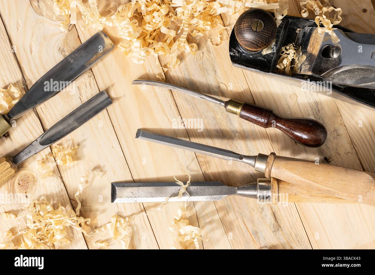 Blick von oben auf ein traditionelles Zimmermannswerkzeug und Holzspäne, die auf Holzdielen liegen Stockfoto