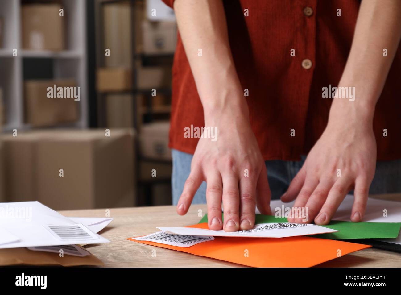 Frau, die Barcodes auf Briefumschläge am Tisch in der Post, Nahaufnahme Stockfoto