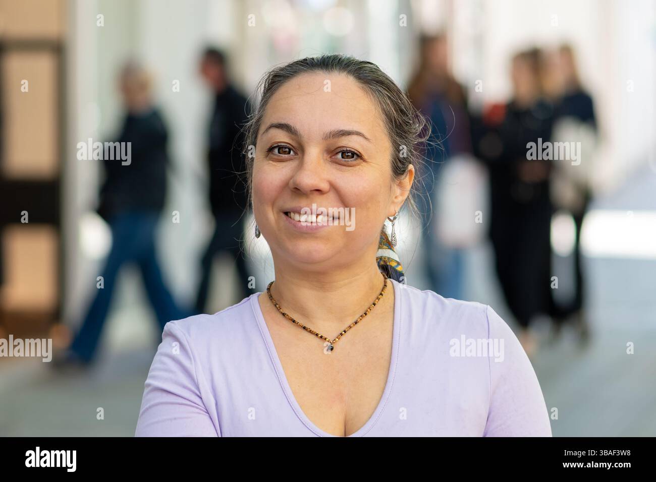Ruhiges Porträt einer 40-45-jährigen Frau in schwarzer Kleidung, die im Stadtzentrum steht Stockfoto