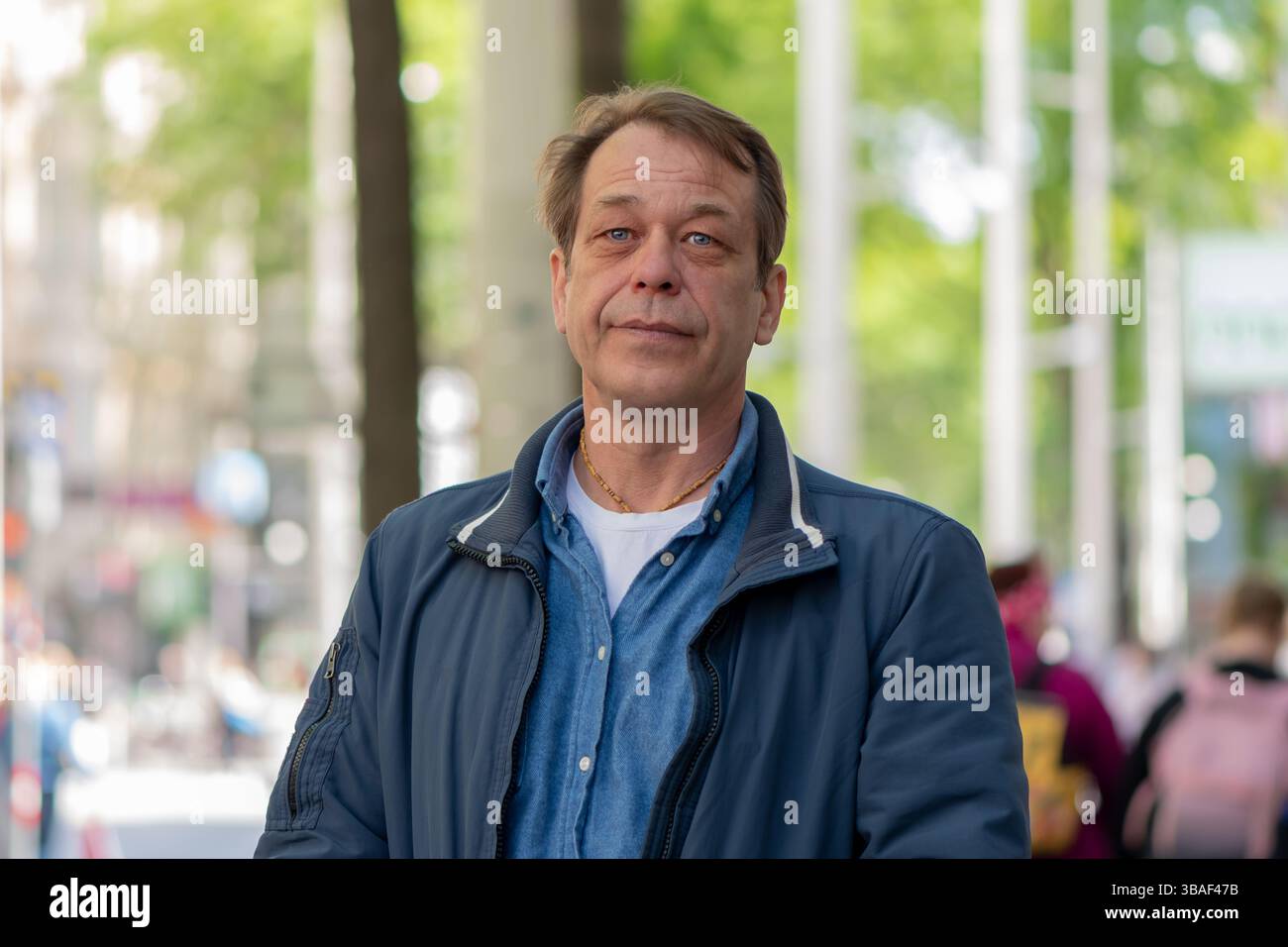 Selbstbewusster reifer Mann starrt in die Kamera in einer städtischen Umgebung Stockfoto