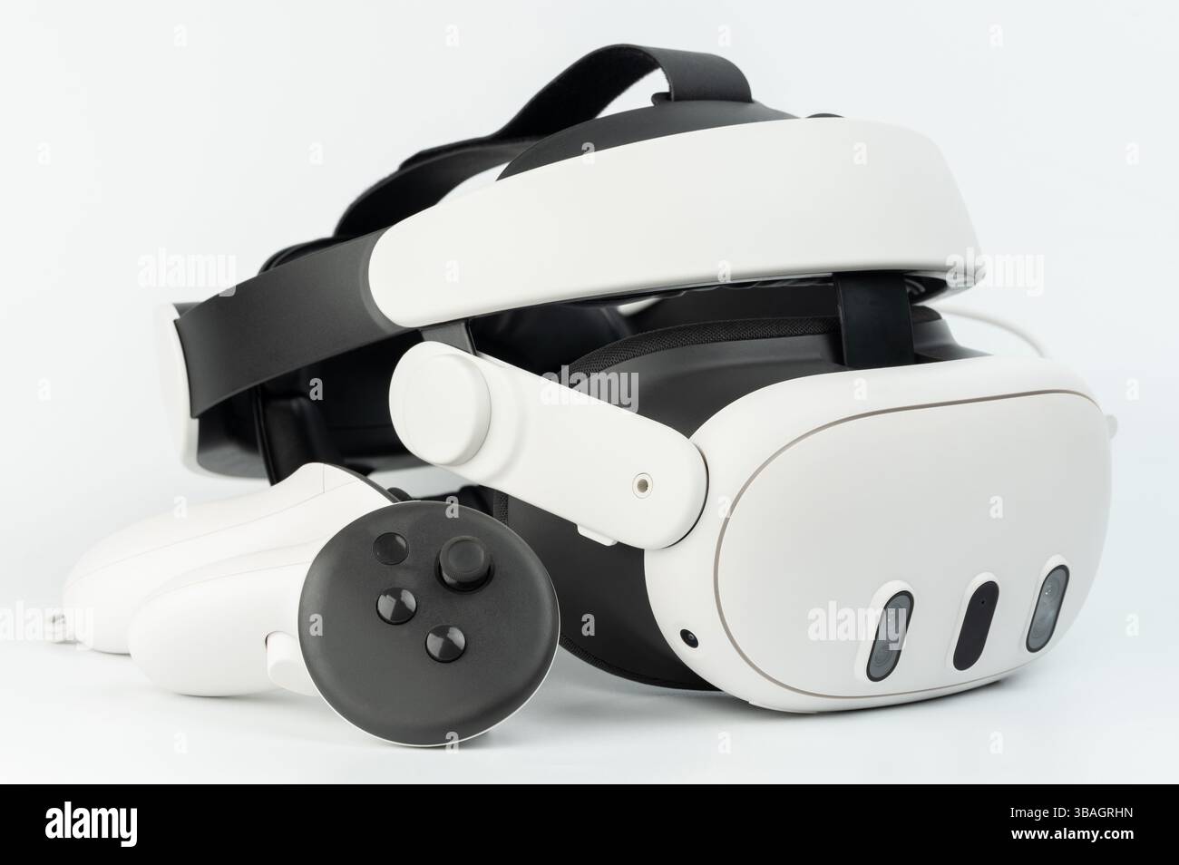 Elegantes Virtual-Reality-Headset mit Controller auf weißem Hintergrund mit futuristischen Designelementen. Stockfoto