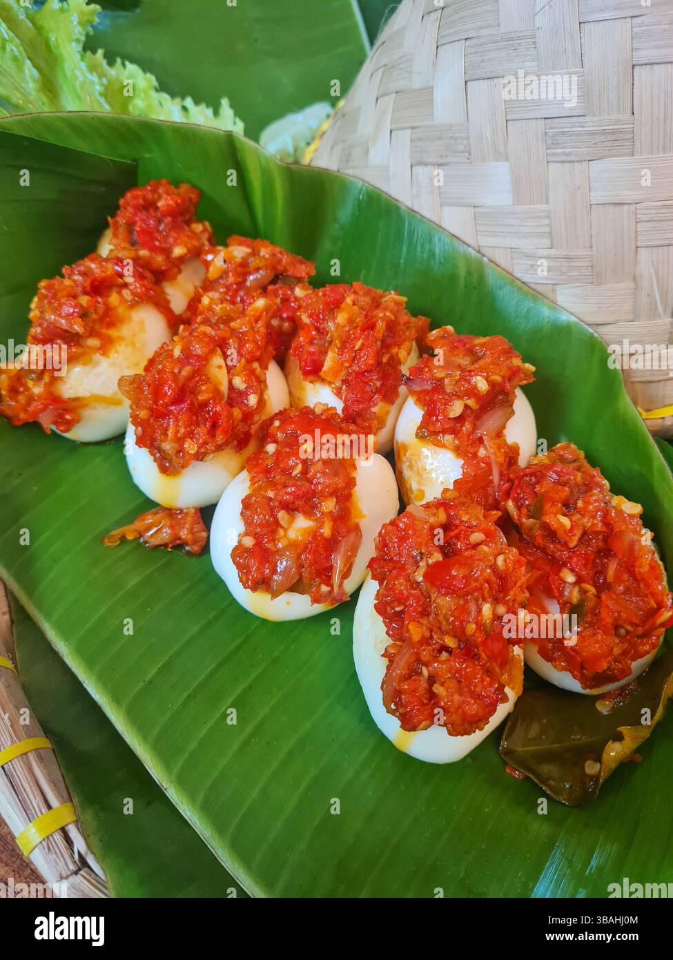 Telur Balado oder gekochte Eier mit rotem Chili Sambal Balado, indonesisches Minangkabau Padang Essen aus West Sumatra, serviert auf einem Bananenblatt Stockfoto