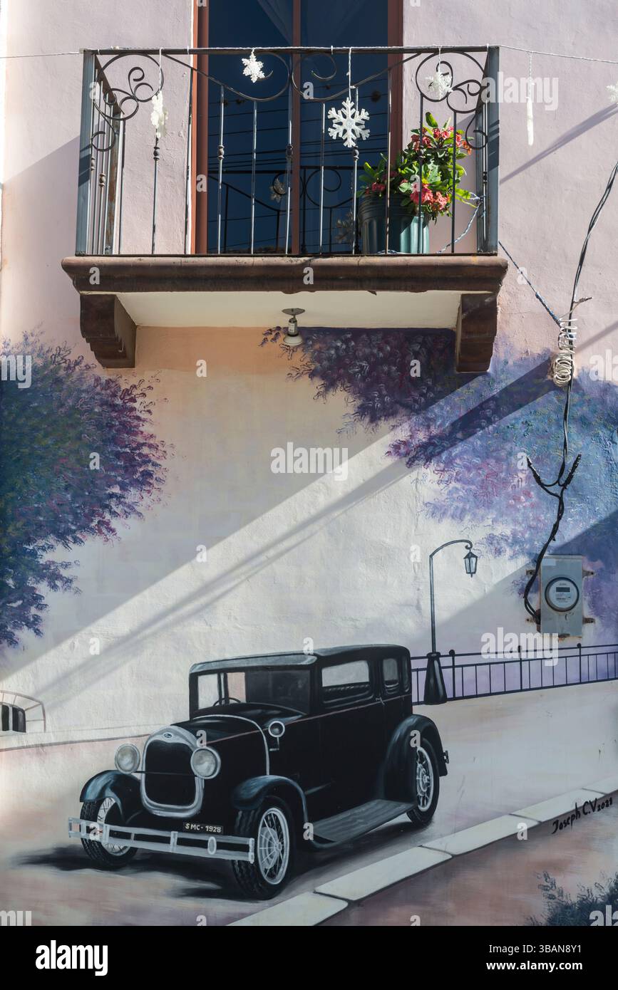 Wandbild eines fahrenden T Ford unter einem eisernen Balkon eines Hauses in San Marcos de Colon, Chaluteca Departement, Honduras. Stockfoto