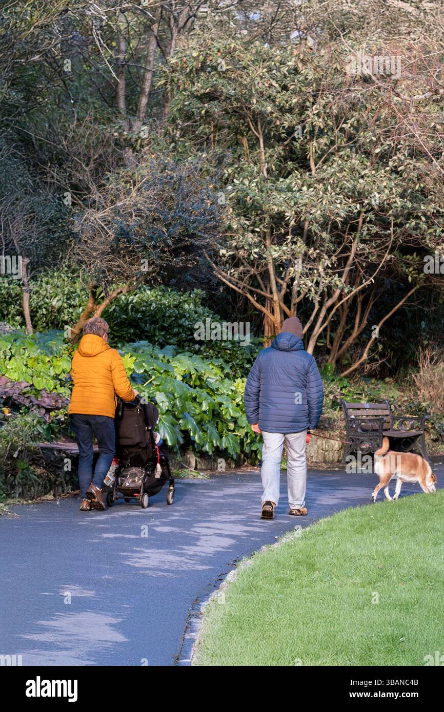 Eine junge Familie, die durch die subtropischen Trenance Gardens in Newquay in Cornwall in Großbritannien spaziert. Stockfoto