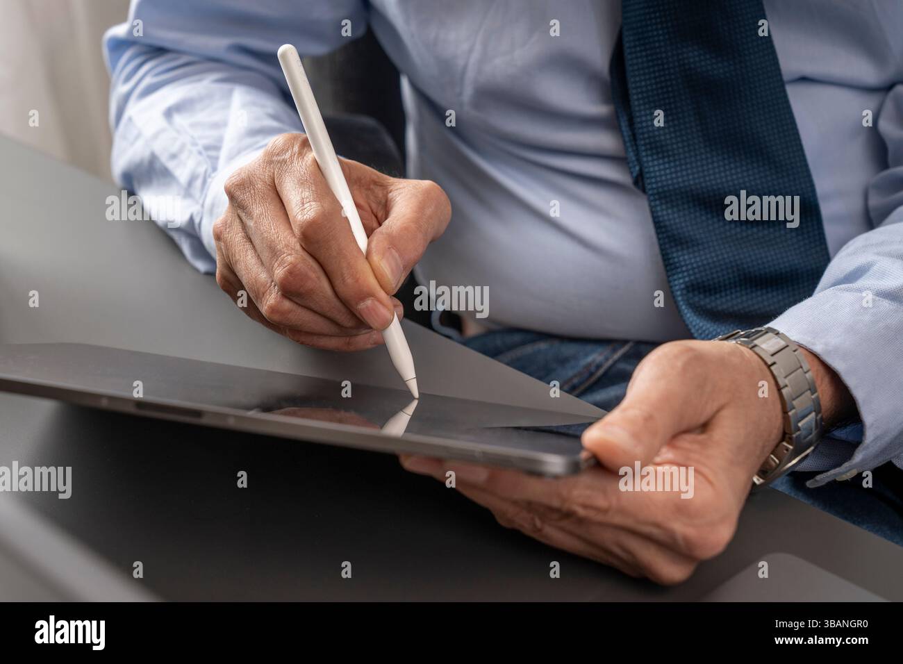 Nahaufnahme reifer männlicher Hände mit einem weißen Eingabestift auf einem Tablet, die E-Signatur, digitalen Workflow und moderne Geschäftstechnologie veranschaulicht. Stockfoto