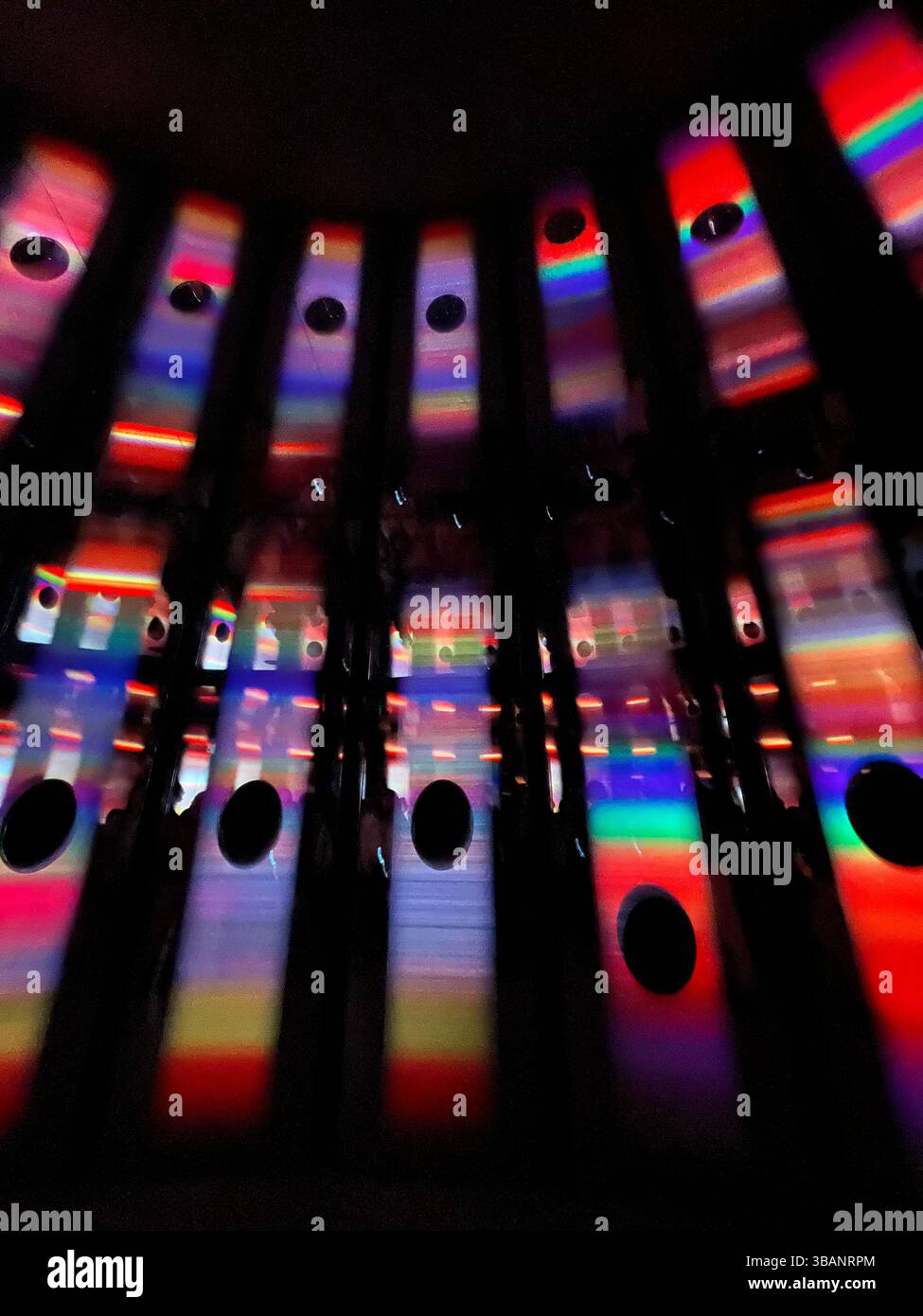 Bunte abstrakte Lichtinstallation mit Regenbogenreflexen in einem dunklen Ausstellungsraum im Women's Pavillion, Expo 2025 - Smartphone-aufgenommenes Stockfoto