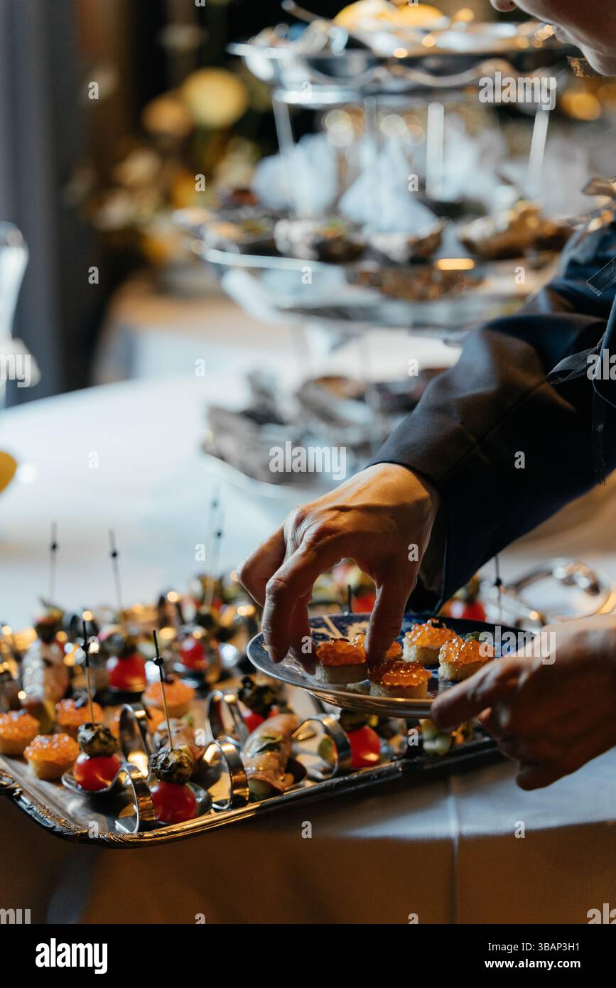 Kleine Sandwiches mit rotem Kaviar auf einem schönen Tablett. Vorspeisen für eine Veranstaltung. Stockfoto