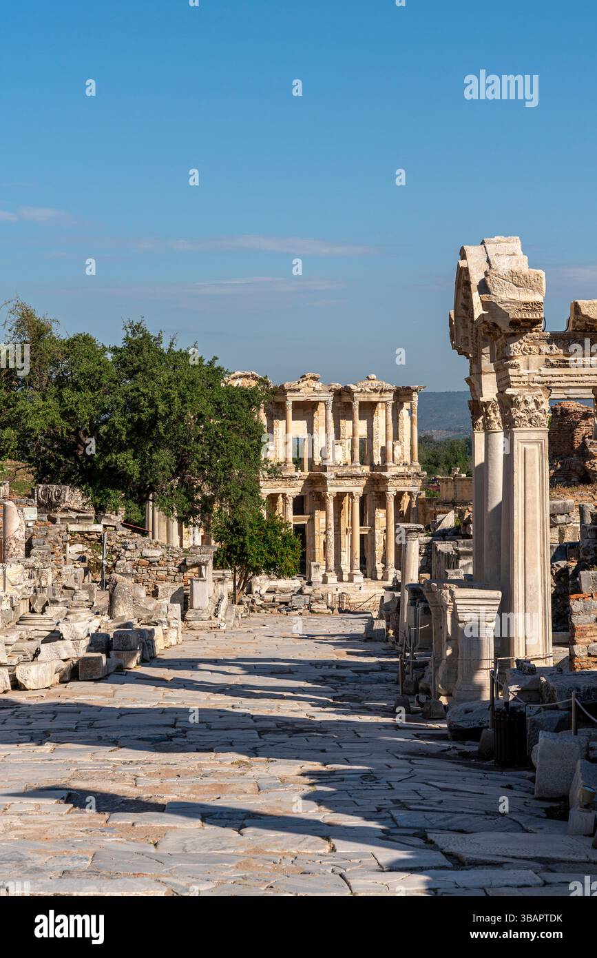 Blick auf die Curetes Street und die Celsus Library in Ephesus, gesäumt von Ruinen und Säulen, die einst die Handelsstraße der Stadt bildeten. Stockfoto