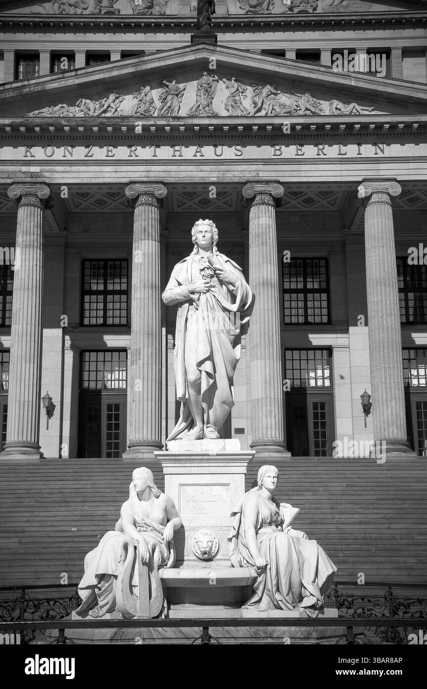 Besucher genießen die atemberaubende Architektur des Konzerthauses Berlin, die Statuen hervorhebt und gleichzeitig die lebendige kulturelle Atmosphäre einlädt. Stockfoto