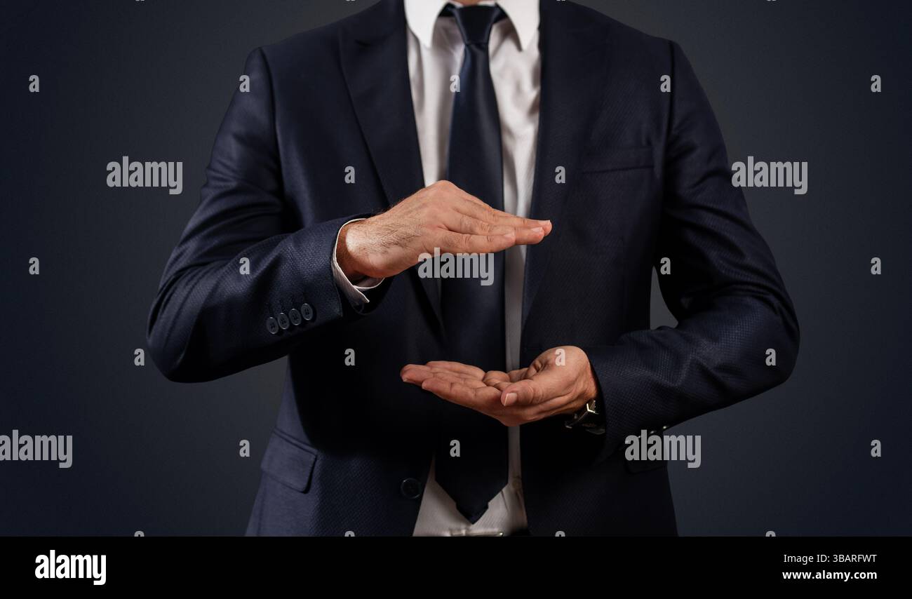 Geschäftsmann mit Gesten, um Text oder Produkte vor schwarzem Hintergrund zu platzieren. Hochwertige Fotos Stockfoto