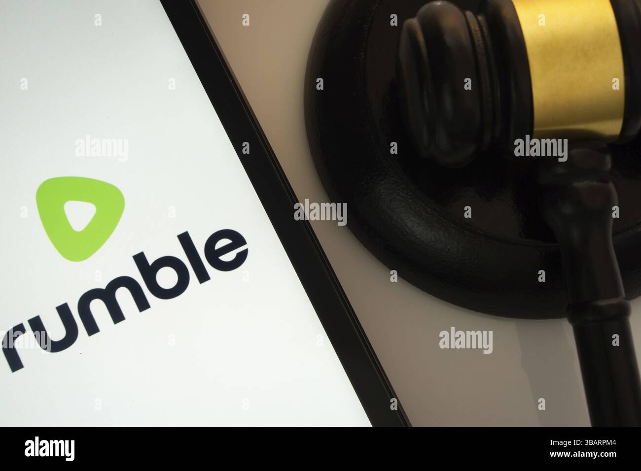 Dhaka, Bangladesch, 18. März 2025: Eine Nahaufnahme eines iPad-Bildschirms, auf dem die Rumble-App neben einem Hammer eines Richters angezeigt wird Stockfoto