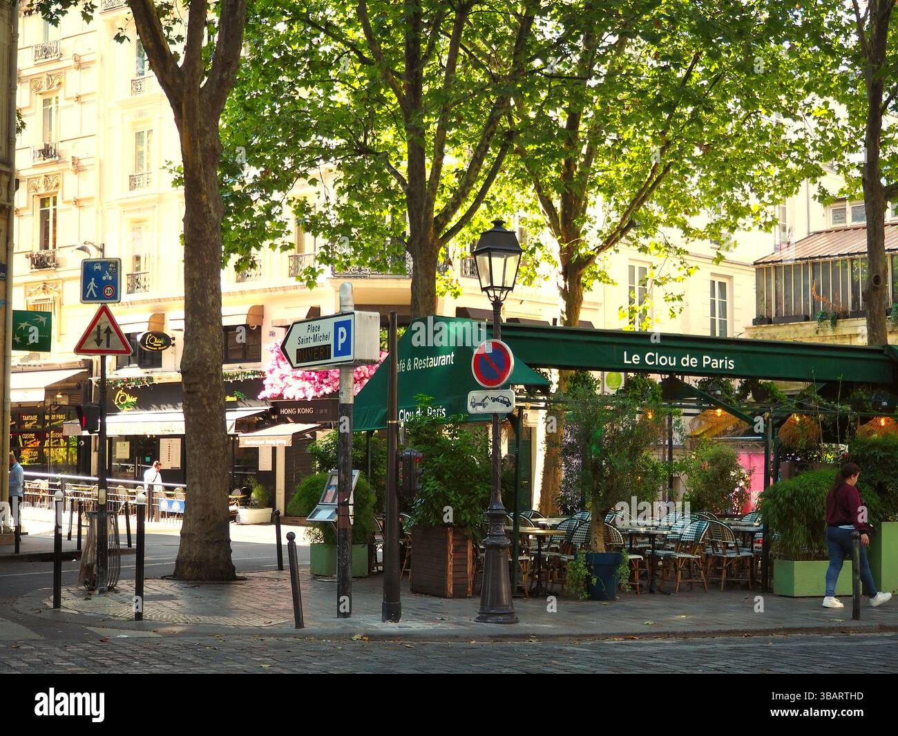 Sonnenverwöhnte Ecke mit grünem Café in Paris, Frankreich Stockfoto