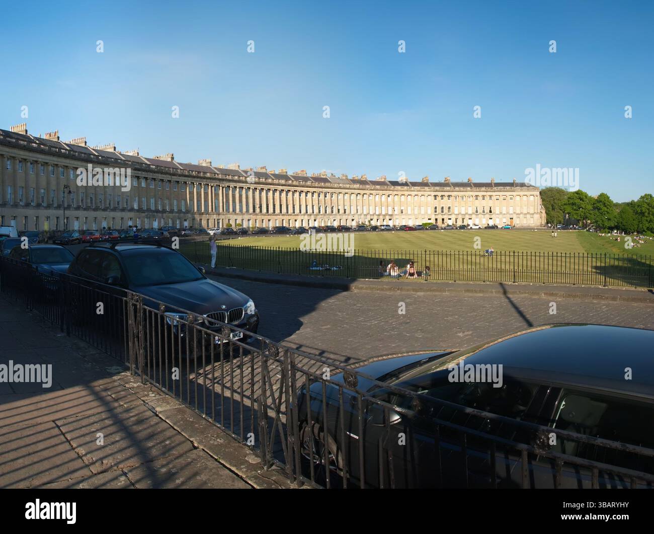 Ein perfekter Tag im legendären Royal Crescent von Bath mit Sonnenschein, Picknicks und Lachen, die das Grün füllen. Stockfoto