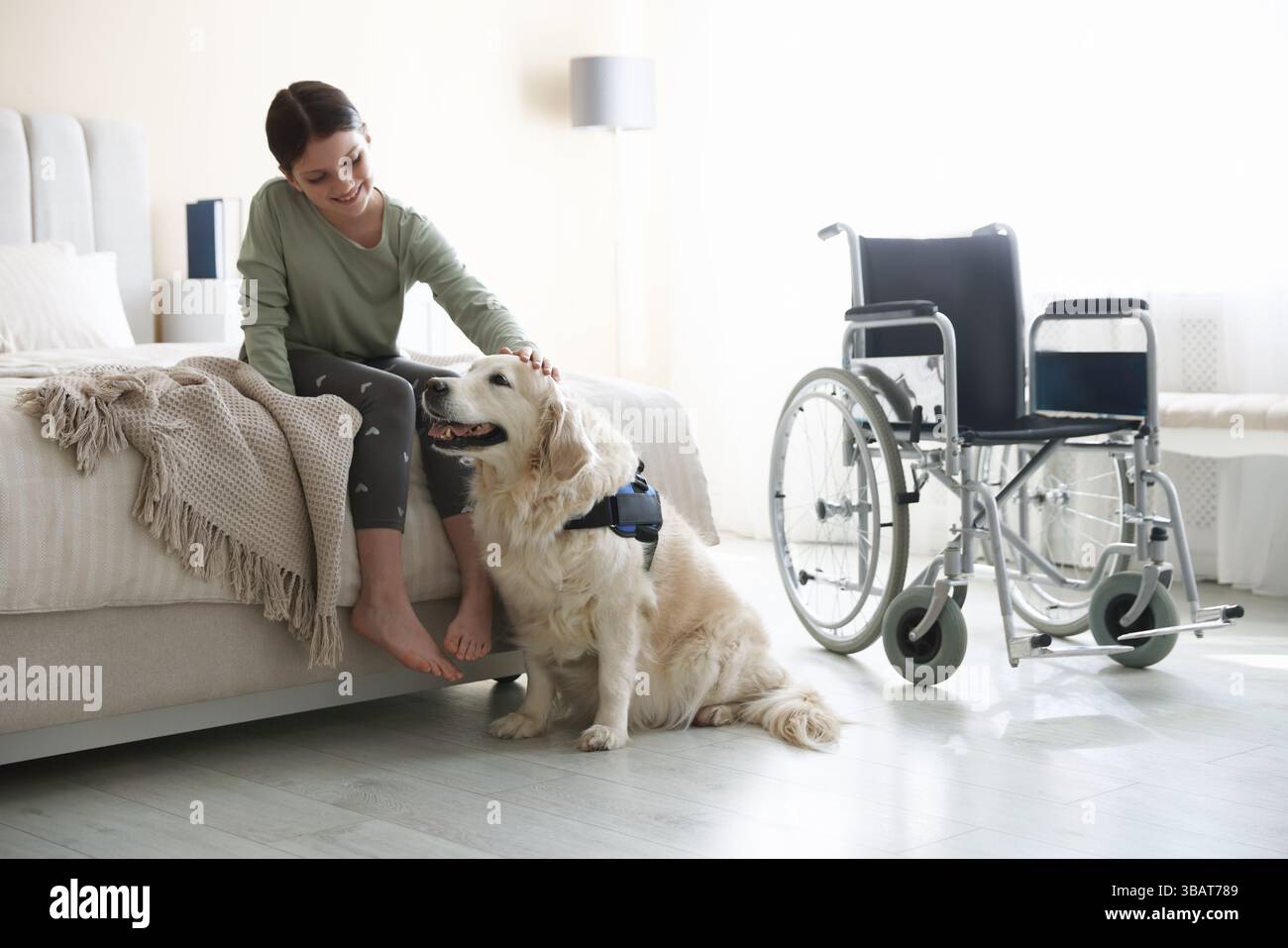 Mädchen mit Behinderung und ihr Diensthund zu Hause Stockfoto