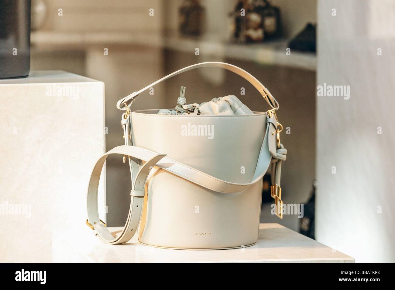 Paris, Frankreich - 23. Februar 2025: Lanvin beige Ledertasche im Boutique-Fenster, goldene Hardware, luxuriöses Modeaccessoire Stockfoto