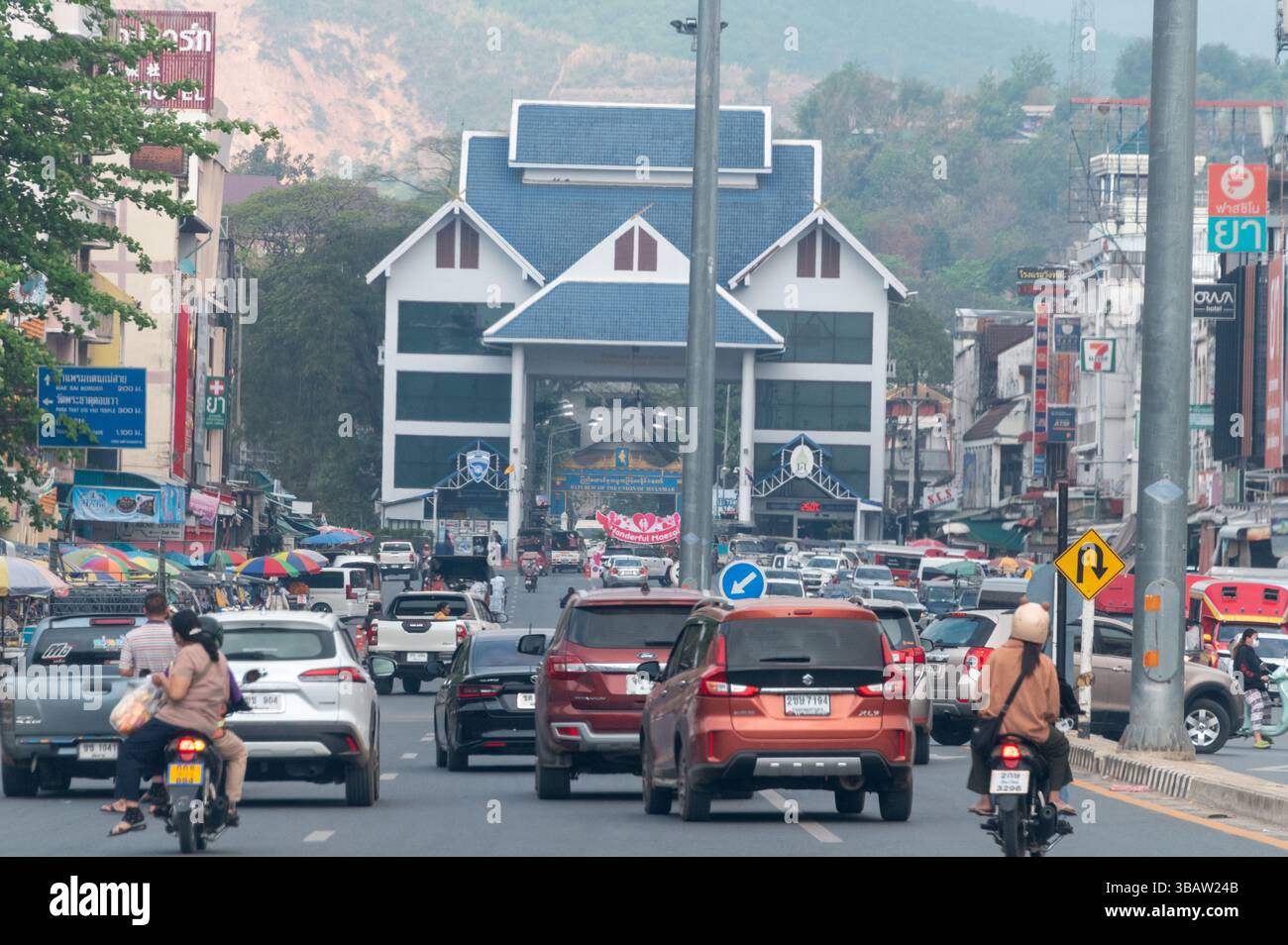 Der Verkehr führt entlang der Hauptstraße in Mae Sai, einer Grenzstadt, in Richtung der Grenze/Zollstelle zwischen Nordthailand und Myanmar. Mae Sai Stockfoto