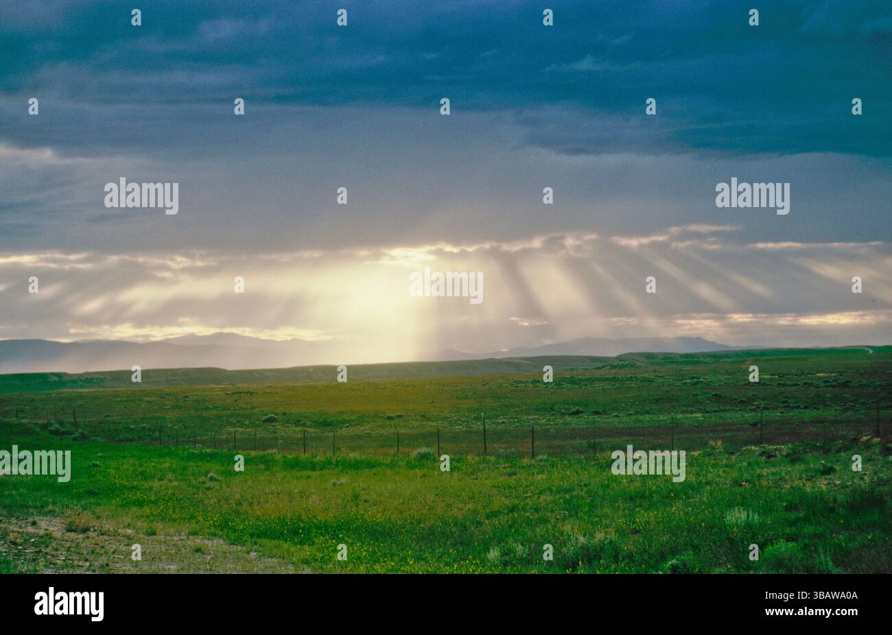 Sonnenlicht leuchtet in den Strahlen durch Wolken nach Regen aus der Ferne, wie der Abend kommt, in South Dakota, USA Stockfoto