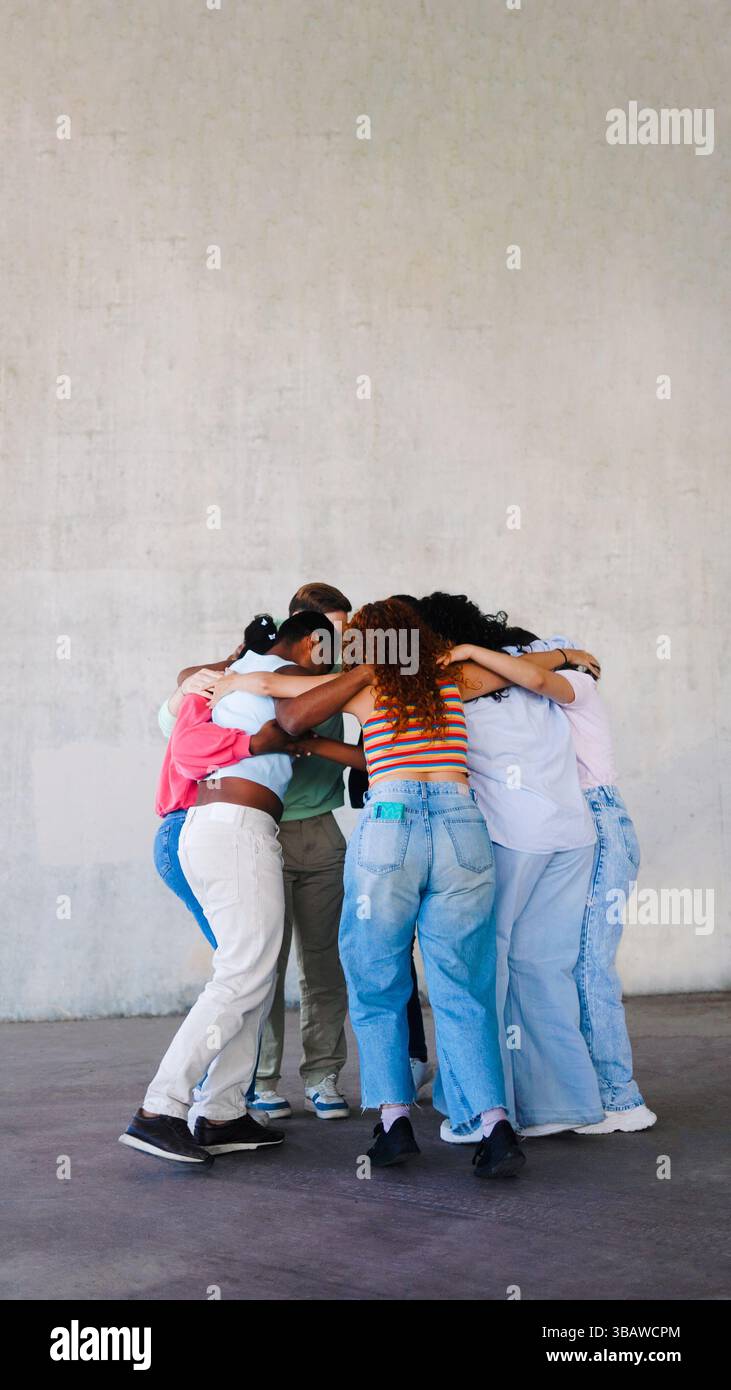 Multirassische Gruppe von Menschen umarmt sich im Kreis draußen. Jugendgemeinschaft, Unterstützung, Einheit, Hilfekonzept Stockfoto
