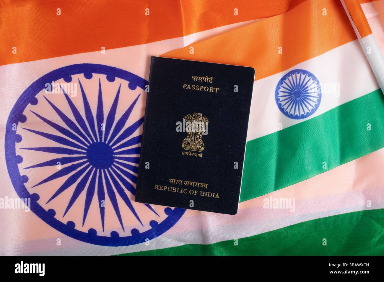 Eine Nahaufnahme eines indischen Passes, der vor der pulsierenden indischen Nationalflagge platziert wird und die persönliche Identität, den Nationalstolz und die internationale Trav symbolisiert Stockfoto Eine Nahaufnahme eines indischen Passes, der vor der pulsierenden indischen Nationalflagge platziert wird und die persönliche Identität, den Nationalstolz und die internationale Trav symbolisiert Stockfoto