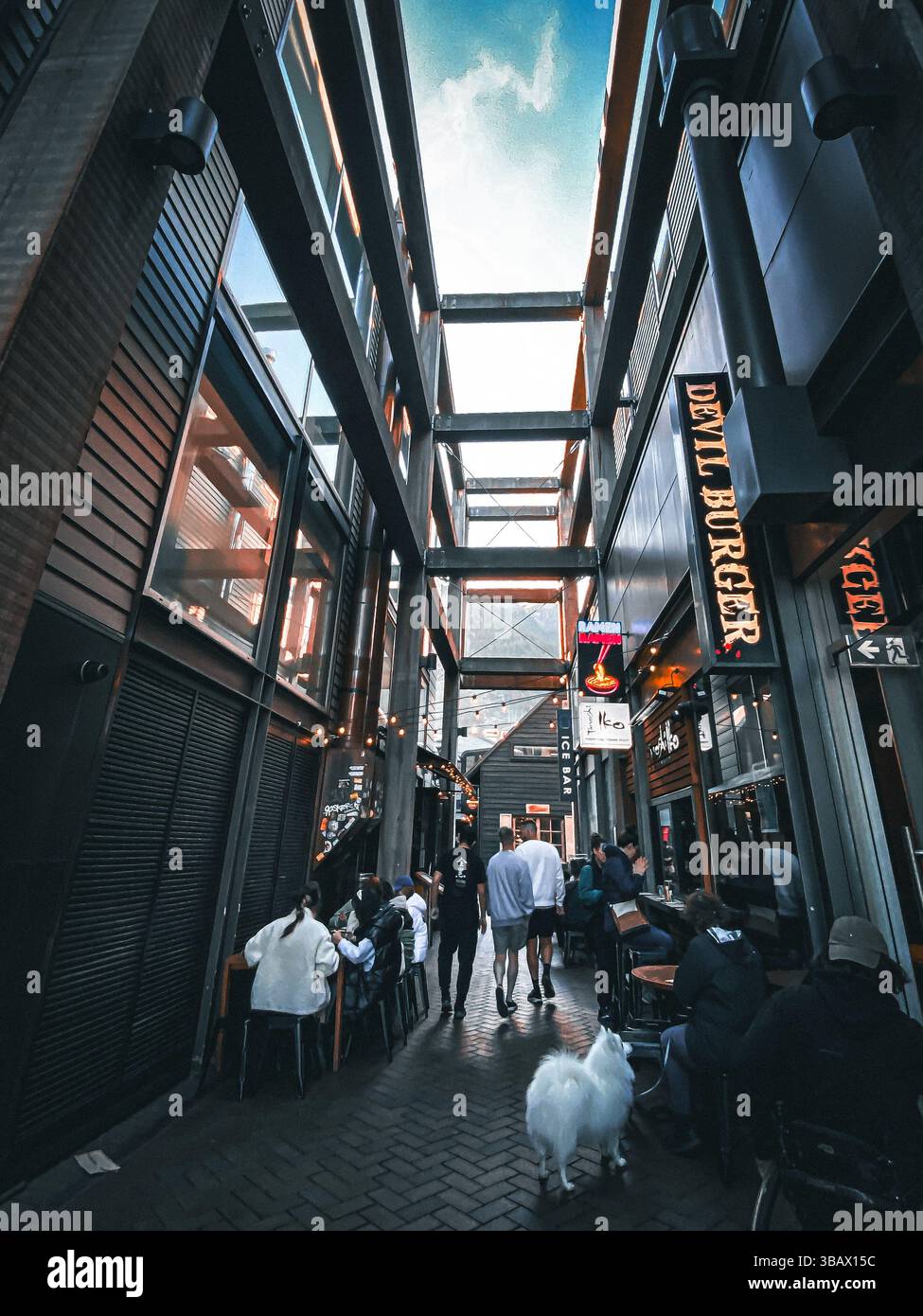 Abendessen am frühen Abend in einer beliebten Seitenstraße in Queenstown, Neuseeland, berühmt für hochwertige Burger und Abenteuertourismus. Stockfoto