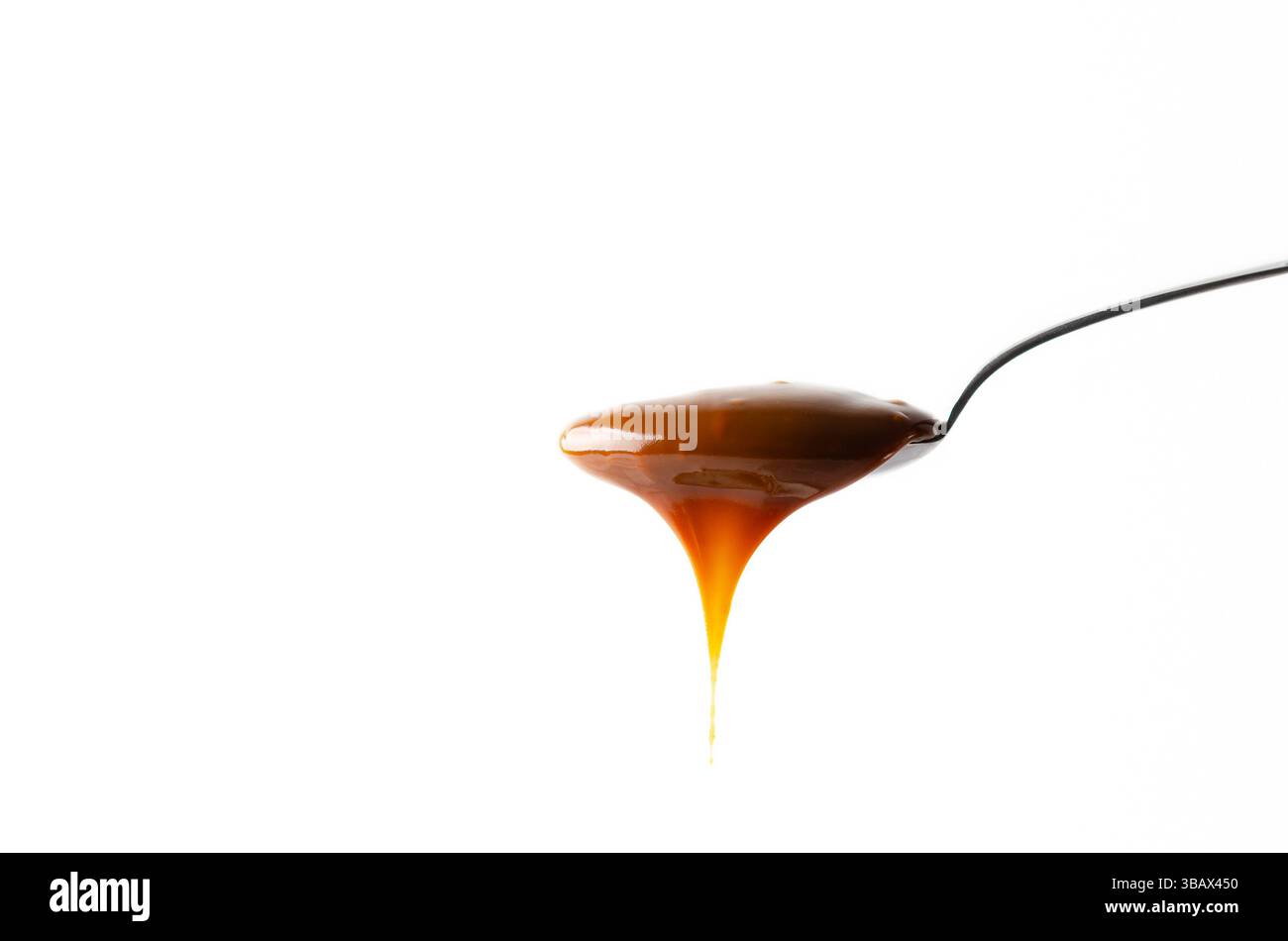 Ein Löffel Dulce de leche auf weißem Hintergrund und Kopierraum. Stockfoto
