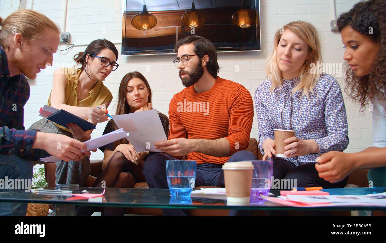 Multikulturelles Business-Team Sitzt Auf Sofa Im Büro Und Prüft Dokumente Stockfoto