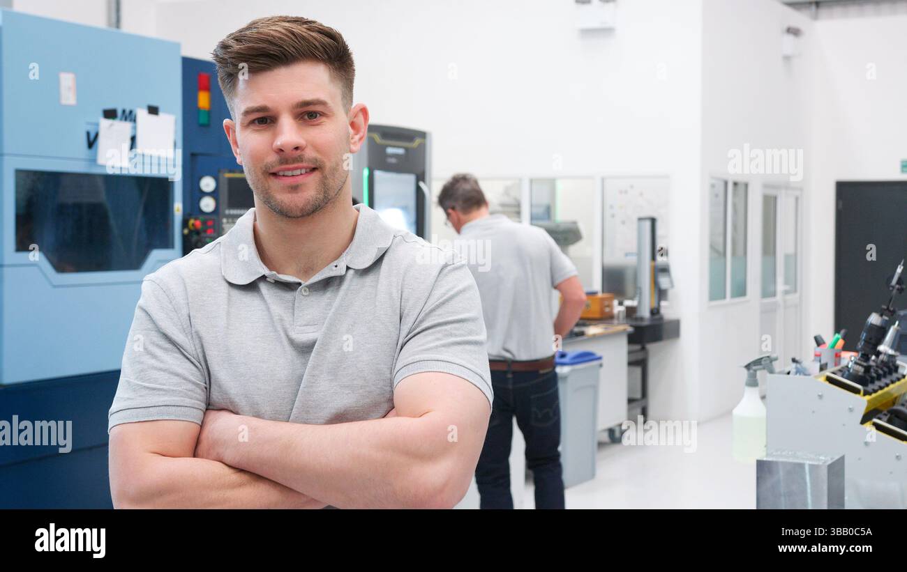Portrait der männlichen Ingenieur auf Fabrikhalle des geschäftigen Workshop Stockfoto