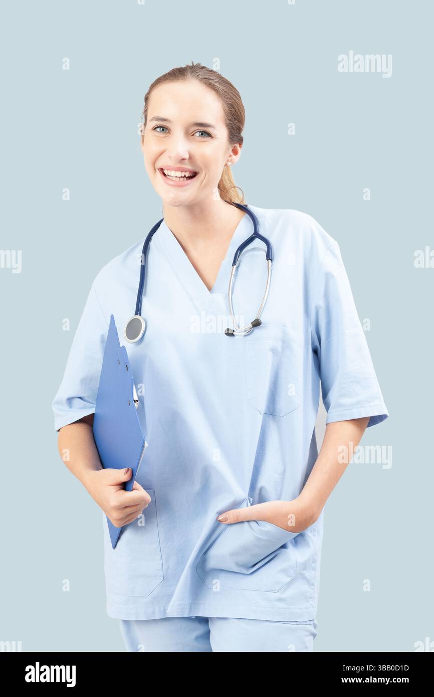 Junge Krankenschwester oder Ärztin lächelt, während sie ein Klemmbrett hält. Medizinisches Fachpersonal mit hellblauen Peelings und Stethoskop. Isoliert am Stockfoto