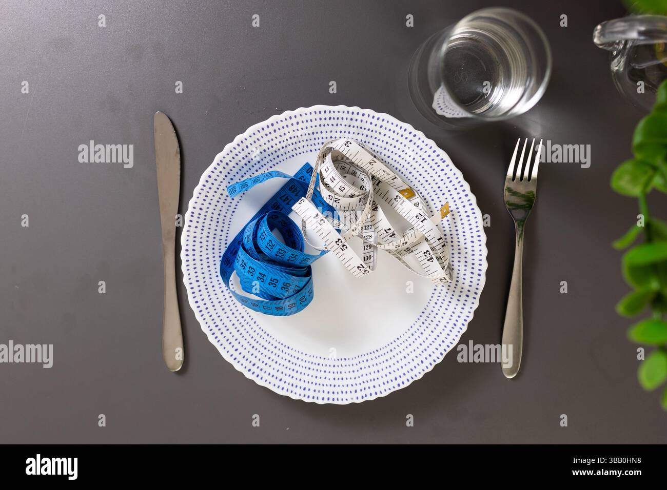Maßband auf einem Teller serviert mit einem Abendessen, das Konzept einer Essstörung - Anorexie, Bulimie. Hochwertige Fotos Stockfoto