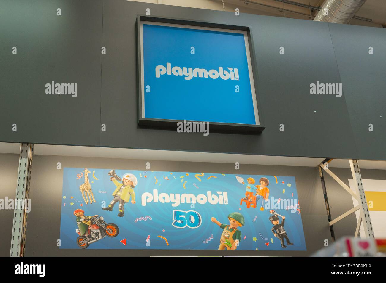 Bad Hersfeld, Deutschland, 04.21.25. Playmobil 50-jähriges Jubiläumsdisplay mit verspielten Charakteren auf einem lebendigen Schild im Ladenlokal. Mit dem Stockfoto