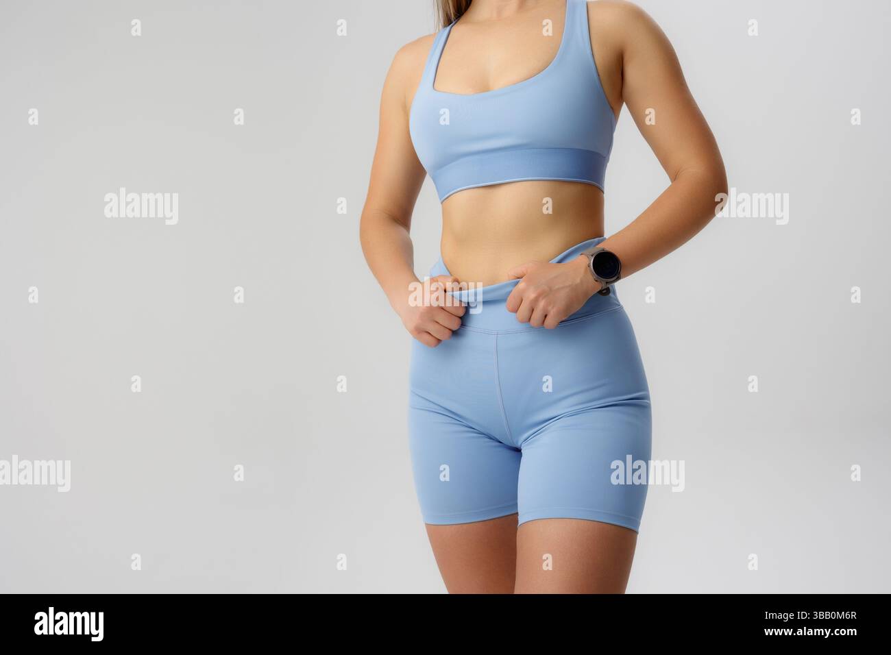 Individuelle Passform passt die blaue Sportkleidung während eines Workouts in einem Studio an Stockfoto
