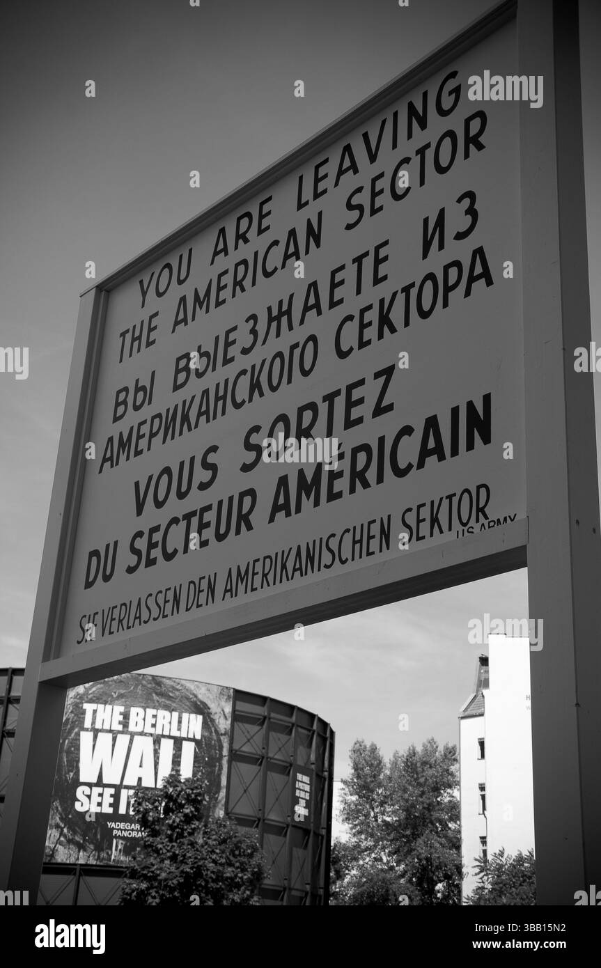 Ein Schild warnt Reisende, dass sie den amerikanischen Sektor in Berlin verlassen und zeigt die historischen Trennungen der Stadt während des Kalten Krieges. Stockfoto