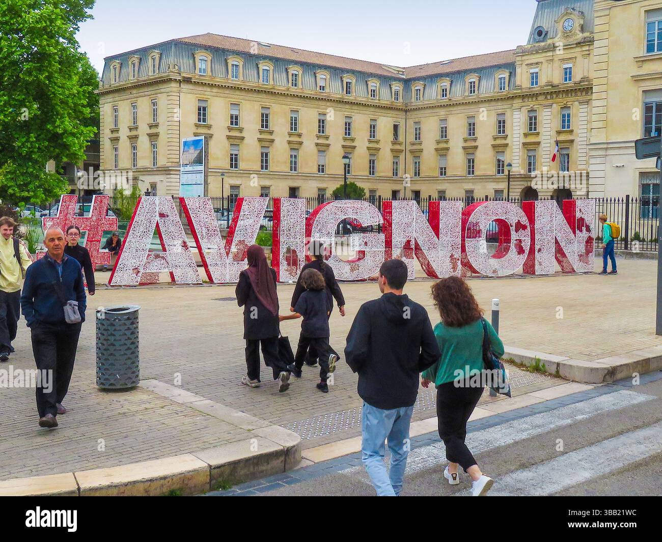 Frankreich, Fußgänger im Zentrum von Avignon mit roten Buchstaben des Avignon-Schildes. Stockfoto