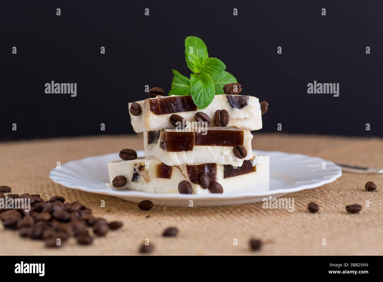 Zarte Milchgelee auf einem Teller mit einem Minzzweig. Stockfoto