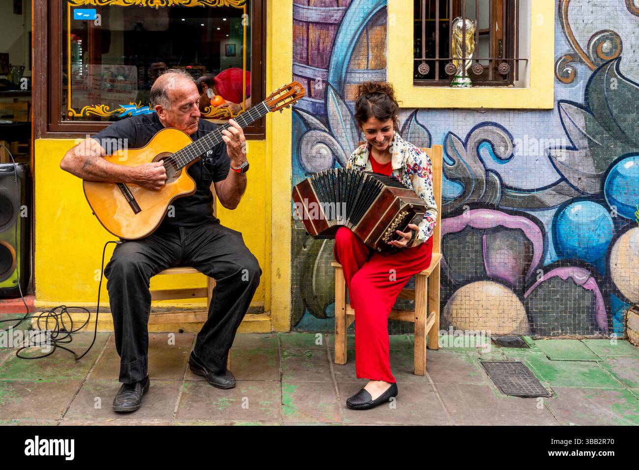 Zwei Musiker spielen vor Einem Restaurant im farbenfrohen Viertel La Boca in Buenos Aires, Argentinien. Stockfoto