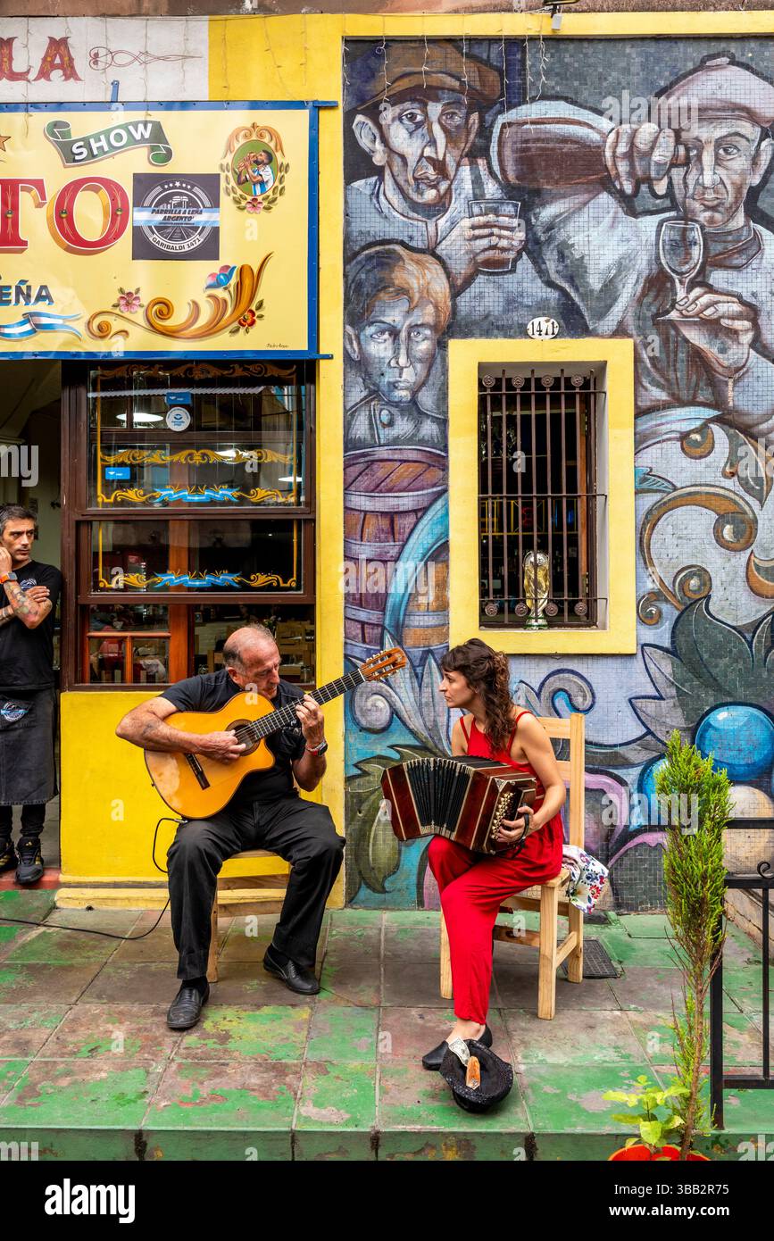 Zwei Musiker spielen vor Einem Restaurant im farbenfrohen Viertel La Boca in Buenos Aires, Argentinien. Stockfoto
