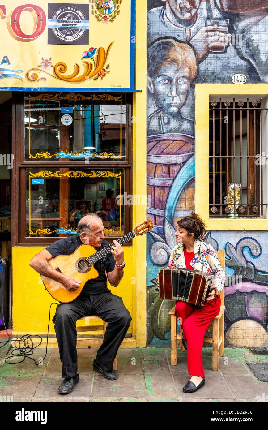 Zwei Musiker spielen vor Einem Restaurant im farbenfrohen Viertel La Boca in Buenos Aires, Argentinien. Stockfoto